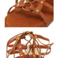 Brown sandals close-up: smooth sole, studded strap, and tied lace details