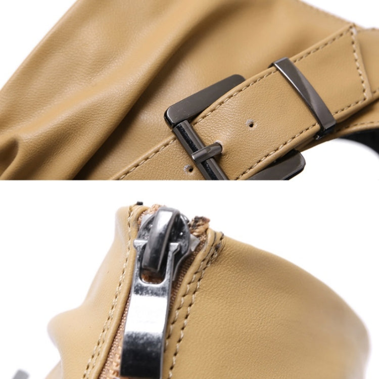 Close-up of light brown sandal strap with metal buckle and stitched leather trim