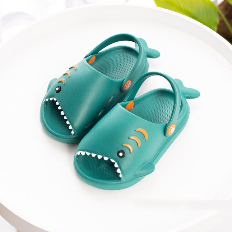 Teal children's shark slippers with open toes, white teeth, and heel straps