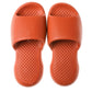 Orange plastic slide slippers with textured footbed and wide open toe, pair view