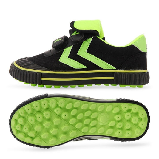 Kids black and neon green soccer shoes with hook-and-loop straps and turf studs