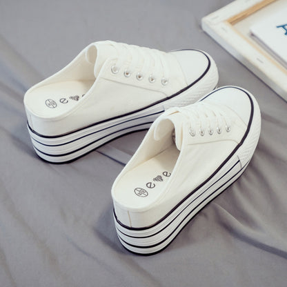White canvas platform slip-on sneakers with lace-up front and thick stacked sole