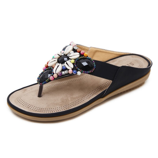 Black beaded thong sandal with shell and jewel embellishments and a perforated footbed