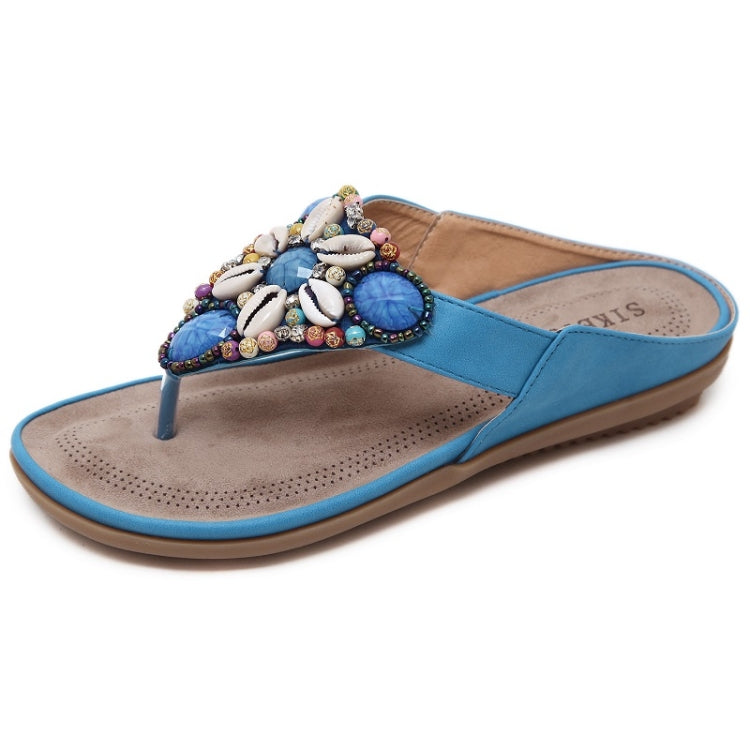 Blue casual thong sandals with beaded shell cluster on the upper and flat sole