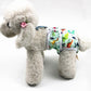 Dog anti-harassment pants with dinosaur print, worn by a plush white dog.
