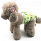 Dog anti-harassment pants with green jungle animal print, worn by a plush brown dog.