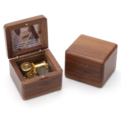 Walnut wooden music box with hinged photo frame, open with gold-toned movement inside