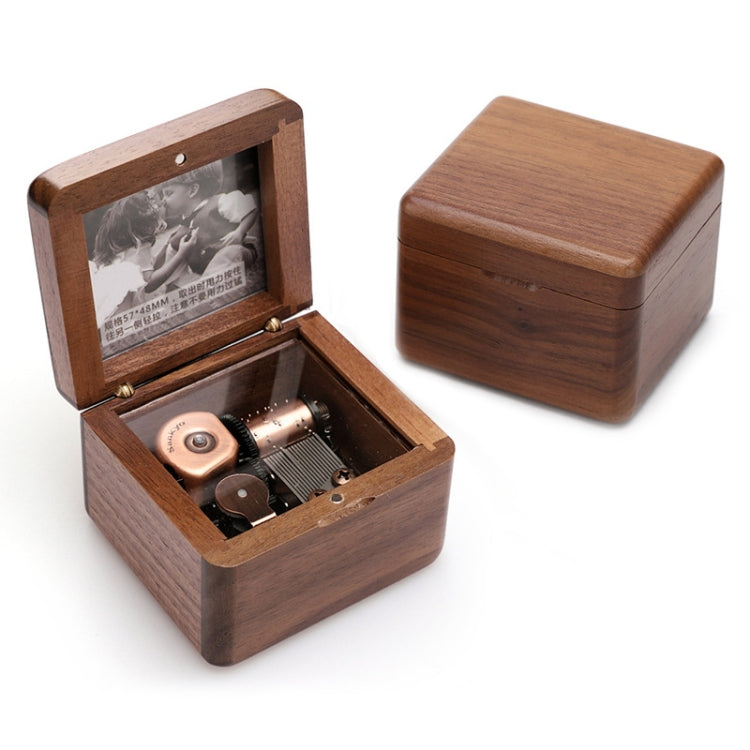 Dark wood music box with hinged lid, open metal music mechanism
