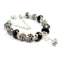 Crystal beaded bracelet with black faceted beads, ornate silver-tone spacers, and chain extender
