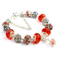 Red faceted crystal bead bracelet with ornate silver-tone spacers and gem-accent charm beads