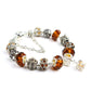 Orange crystal beaded bracelet with silver-tone charms, faceted amber beads, chain extender