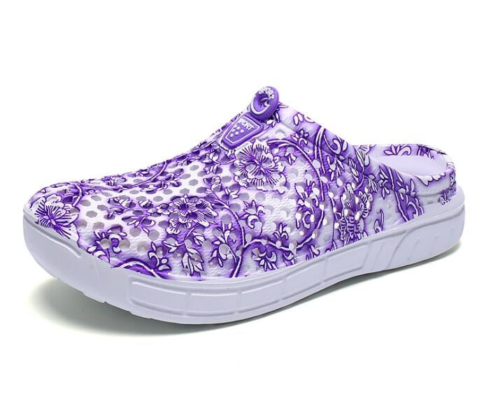 Women's slip-on clogs with purple floral printed fabric and white cushioned sole