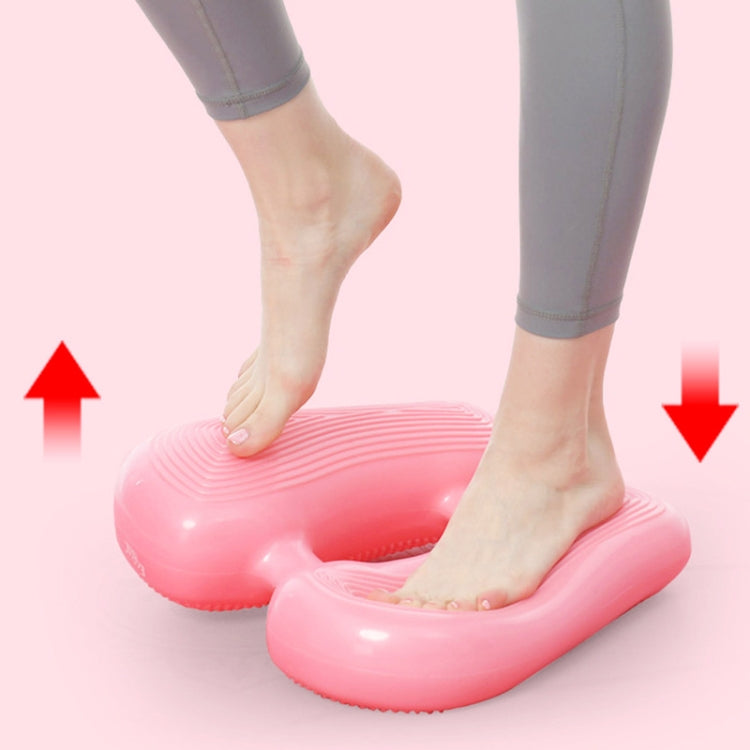 Pink inflatable yoga massage foot pad supporting bare feet for leg exercise