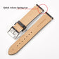 Tan and dark brown leather watch strap showing quick release spring bar at lug end