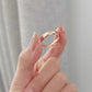 Rose gold and silver narrow rings held in hand, engraved inner text visible