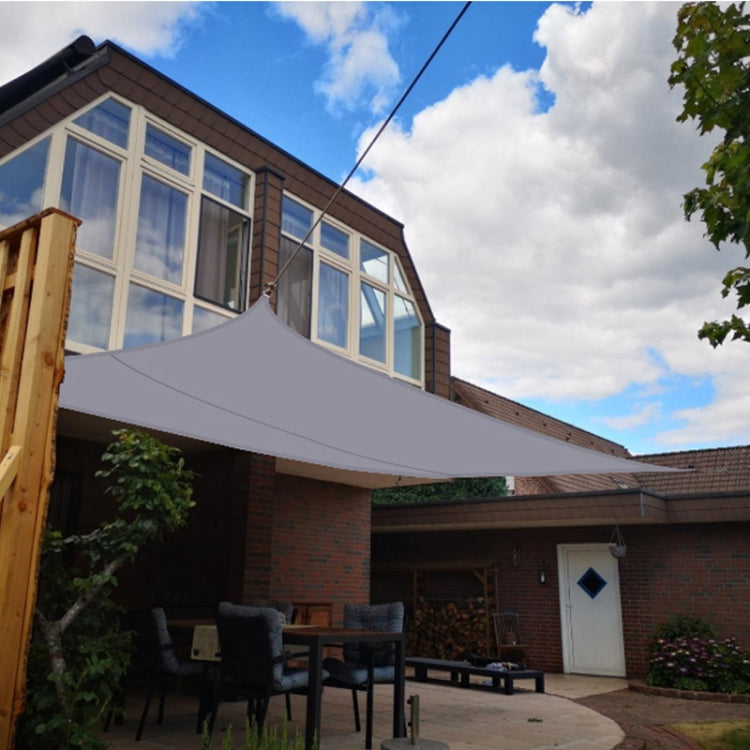 Outdoor garden sunshade sail canopy covering a patio with secured rope anchors