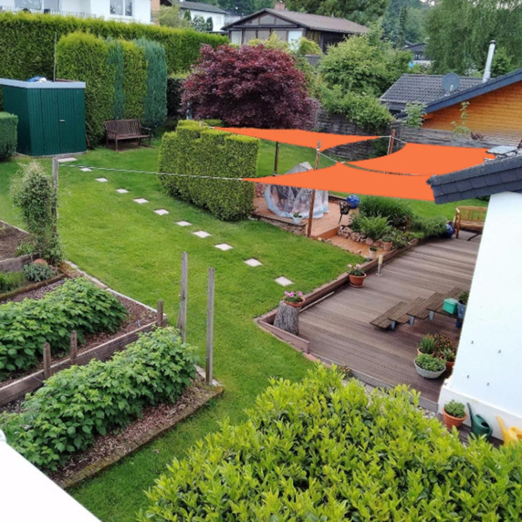 Orange waterproof sunshade sail canopy installed over a backyard patio