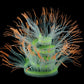 Fluorescent simulated coral anemone with blue tentacles and orange tips, green glow center
