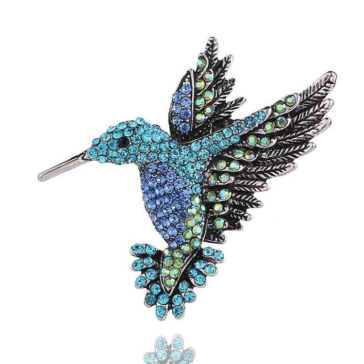 Blue rhinestone bird brooch with layered feather wings and metal pin back