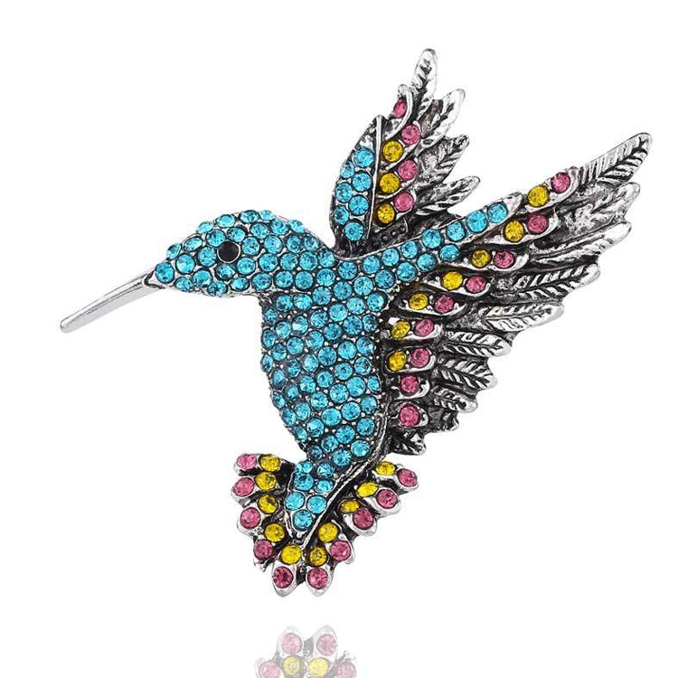Blue rhinestone bird brooch with black enamel feather wings and metal pin back
