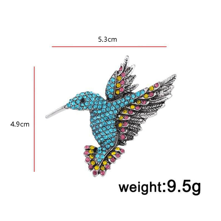 Blue rhinestone bird brooch with colorful accents, layered wings, and metal pin back