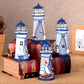 Cluster of blue and white lit tin lighthouse decorations on a wooden block display