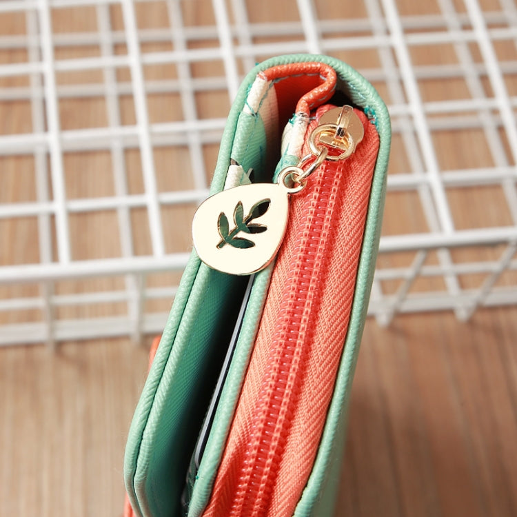 Long zipper wallet corner view with mint green trim and orange zip pocket with charm.