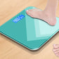 Teal smart electronic scale with blue LCD weight display under a person’s foot