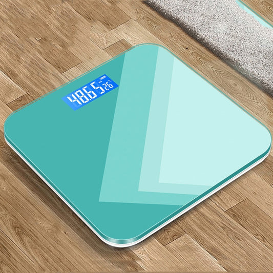 Teal smart body scale with blue LCD showing weight reading on glass platform
