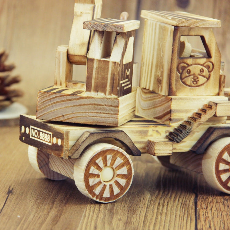 Wooden model excavator toy ornament close-up with large wheels and front bucket, light wood