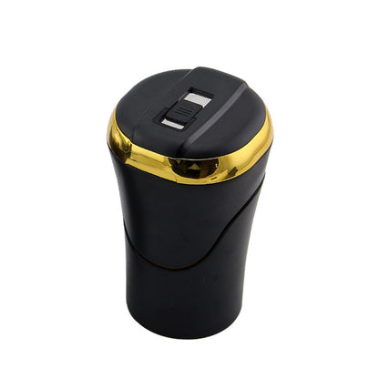 Car ashtray with hinged cover, black body and gold top trim, built-in cigarette holder slot