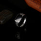 Silver-tone band ring with black enamel top and rhinestone trim, side view