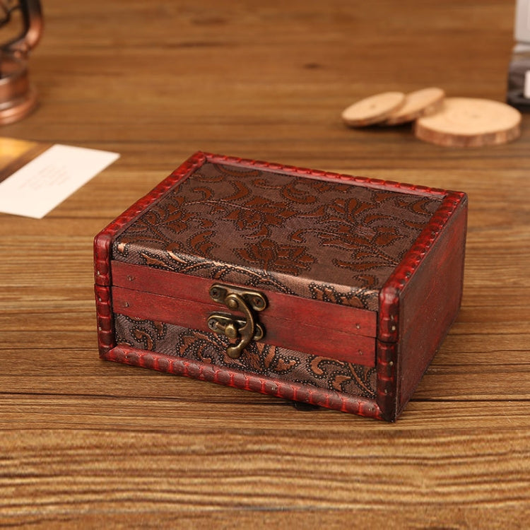 Vintage wooden jewelry box with red sides, dark engraved pattern, and bronze clasp