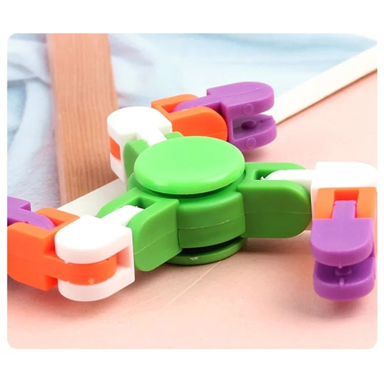 Close-up green plastic finger spinner toy with orange, purple, and white chain blocks