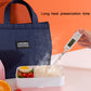 Navy insulated lunch box bag with thermometer probe inserted into the meal