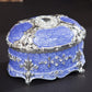 Silver-trim blue oval jewelry storage box with diamond-style top and jeweled front details