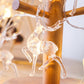 Warm-white elk string lights with glowing LED elk figures on a wooden pole.