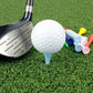 Golf ball on blue tee with colorful wooden ball holders near a club head
