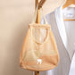 Orange mesh wall-hanging produce storage bag hanging by top loop on a wooden hook
