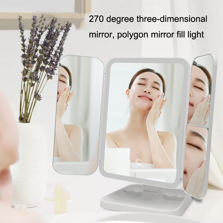 Three-sided folding LED makeup mirror lamp reflecting a face in three panels