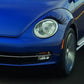 Black eyelash eyebrow headlight sticker on blue car front lamp.