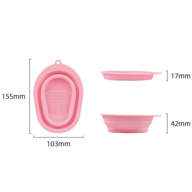 Pink silicone makeup brush cleaning pad with oval loop and textured inner scrub grid.