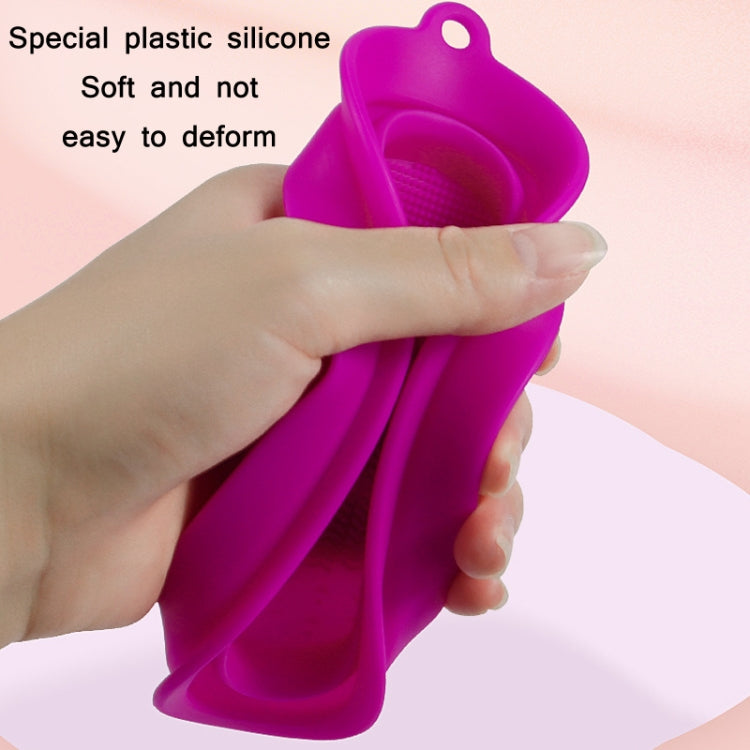 Purple silicone makeup brush cleaning pad with oval loop and textured cleaning surface.