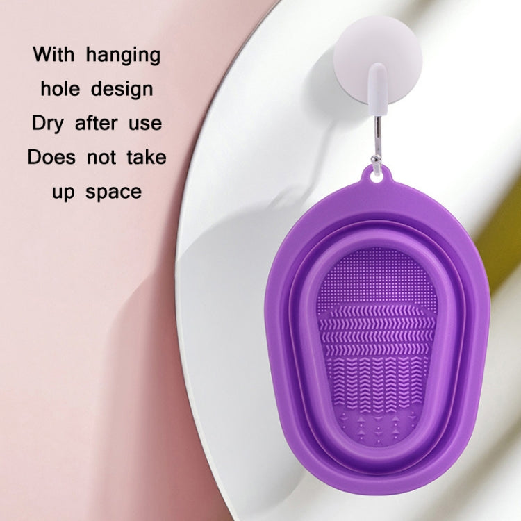 Purple silicone makeup brush cleaning pad with hanging hole and textured scrub interior.