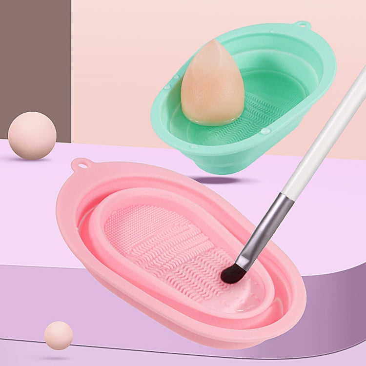Pink and teal silicone makeup brush cleaning pads with textured scrub surfaces.