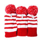 Three red-and-white striped knitted golf club covers with pom-pom tops