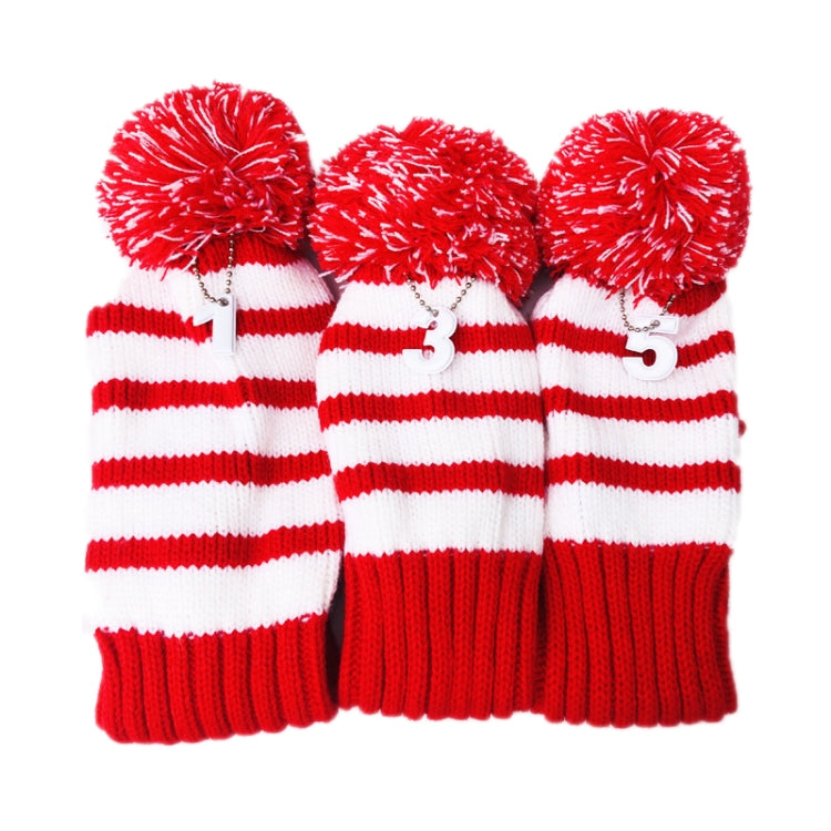 Three red-and-white striped knitted golf club covers with pom-pom tops