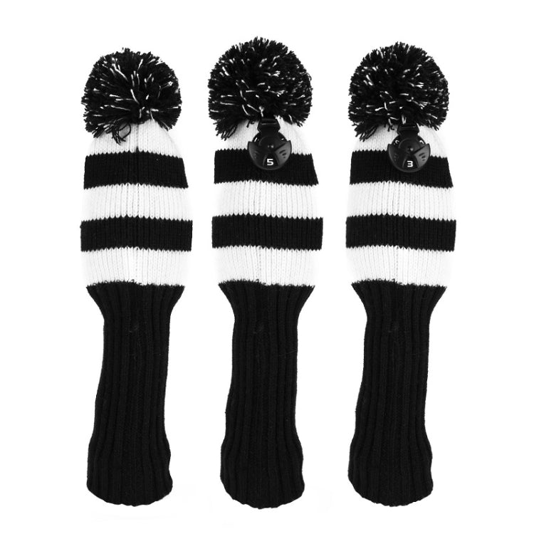 Three black and white striped knitted golf club covers with pom-poms and number tags