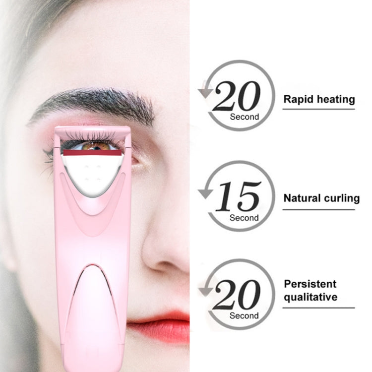 Pink electric eyelash curler near eye with open heating plate for quick curling