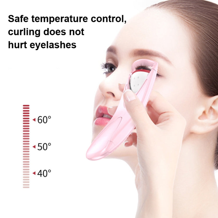 Pink heated eyelash curler being applied to an eye with protective curved guard